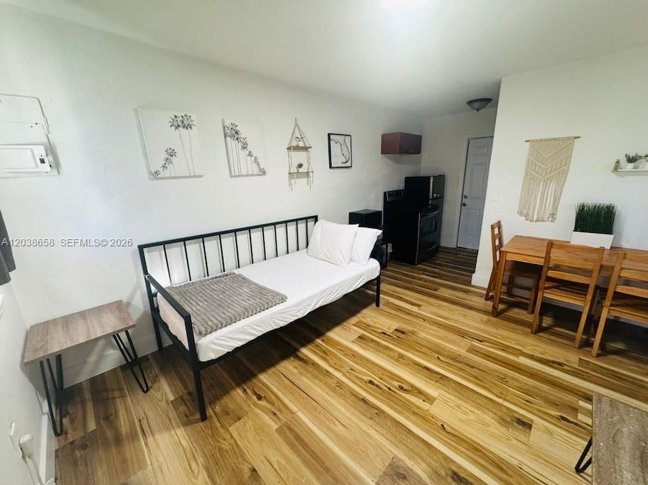 A studio apartment features a daybed, a dining set, and wood-look flooring — 7638 N Miami Ave # 1, Miami FL 33150, MIAMI, FL