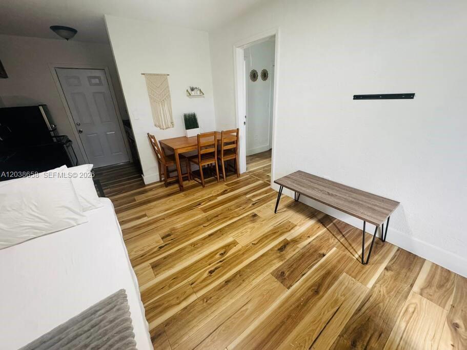 A room features wood-look flooring, a dining set, and a low bench with metal legs — 7638 N Miami Ave # 1, Miami FL 33150, MIAMI, FL