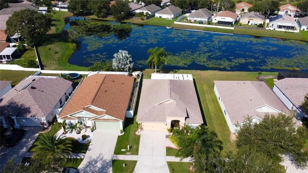 An aerial view shows four suburban houses situated along the edge of a large pond — 12213 RAVENS NEST PLACE, RIVERVIEW, FL