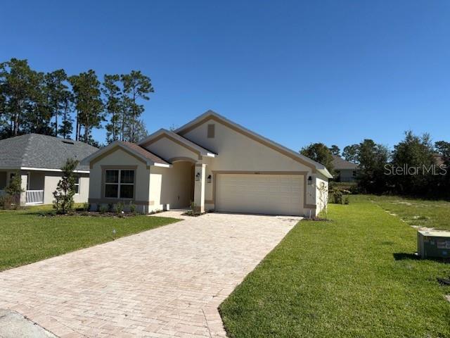 A single-story house with a beige exterior, a two-car garage, and a paved driveway — 7625 SW 180TH CIRCLE, DUNNELLON, FL