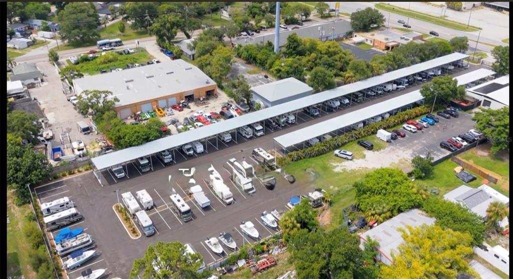 An aerial view shows a storage facility with covered parking for RVs and boats — 4685 PARK STREET N, ST PETERSBURG, FL