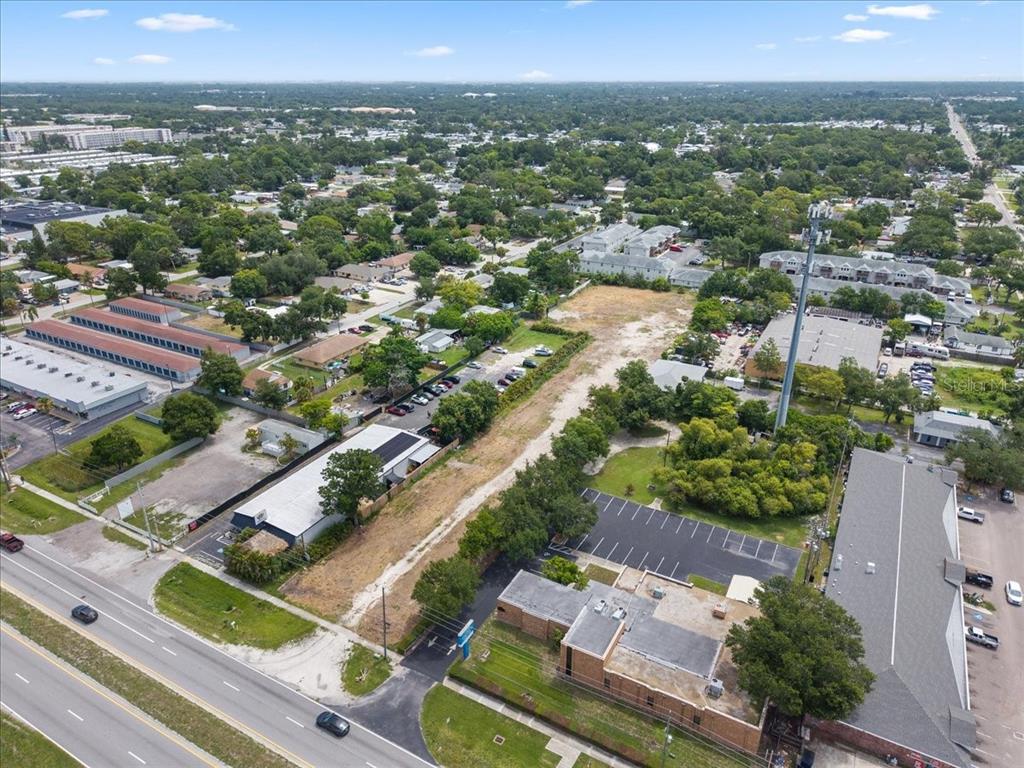 An aerial view shows a commercial property with parking lots, buildings, and a cell tower — 4685 PARK STREET N, ST PETERSBURG, FL