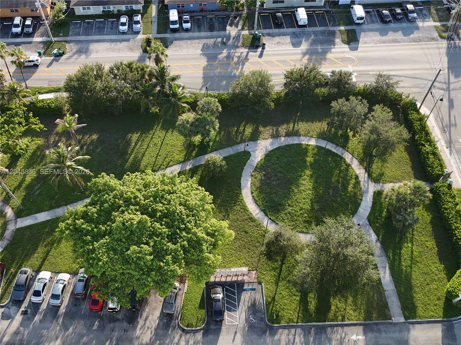 An aerial view shows a park with a circular walking path, trees, and parking lots — 1750 NW 55th Ave # 103, Lauderhill FL 33313, LAUDERHILL, FL