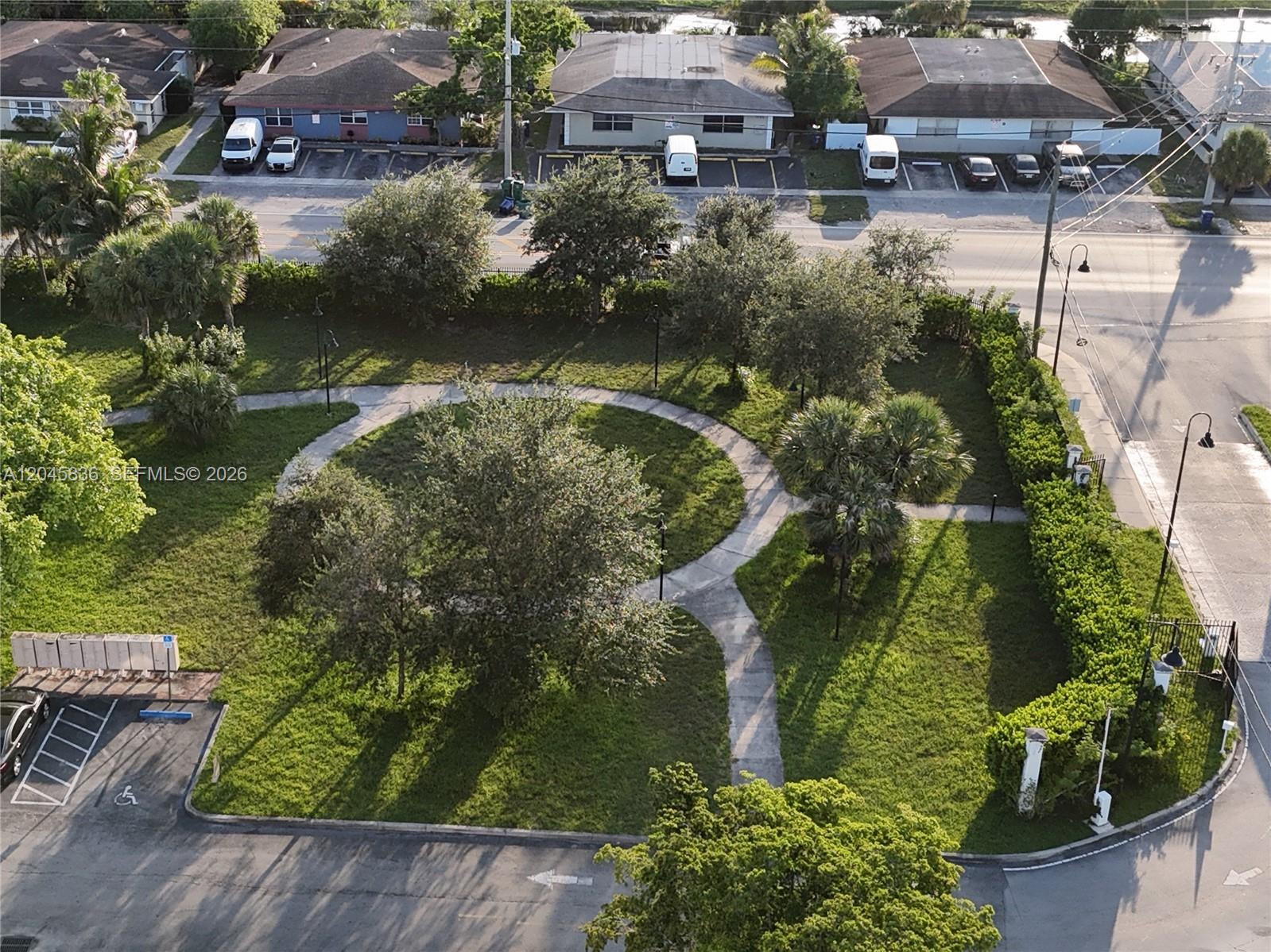 An aerial view shows a small park with paved walkways, trees, and surrounding residential buildings — 1750 NW 55th Ave # 103, Lauderhill FL 33313, LAUDERHILL, FL