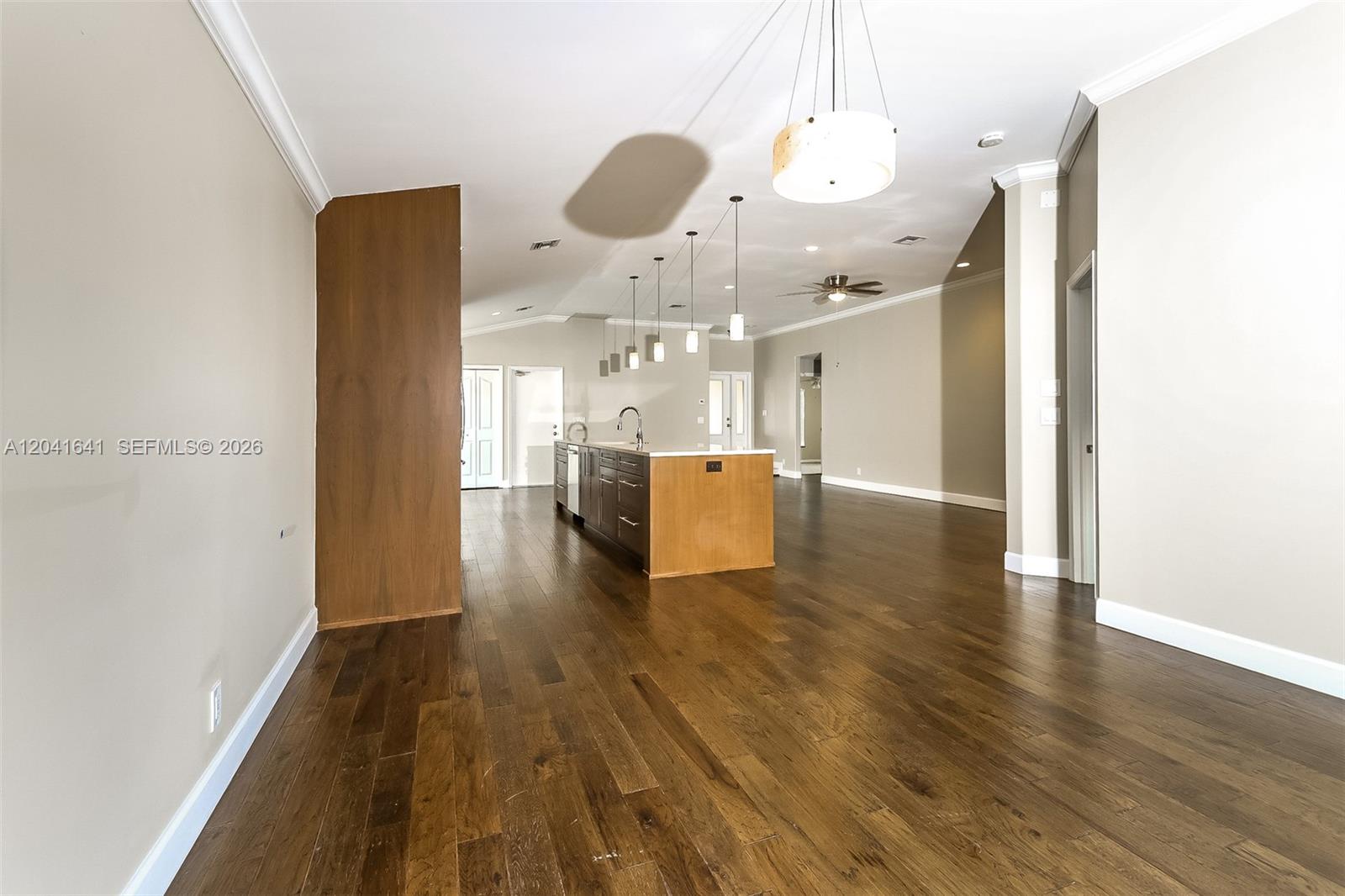 An open-concept kitchen features a wooden island, dark cabinetry, and hardwood floors — 6484 Robinson St, Jupiter FL 33458, JUPITER, FL