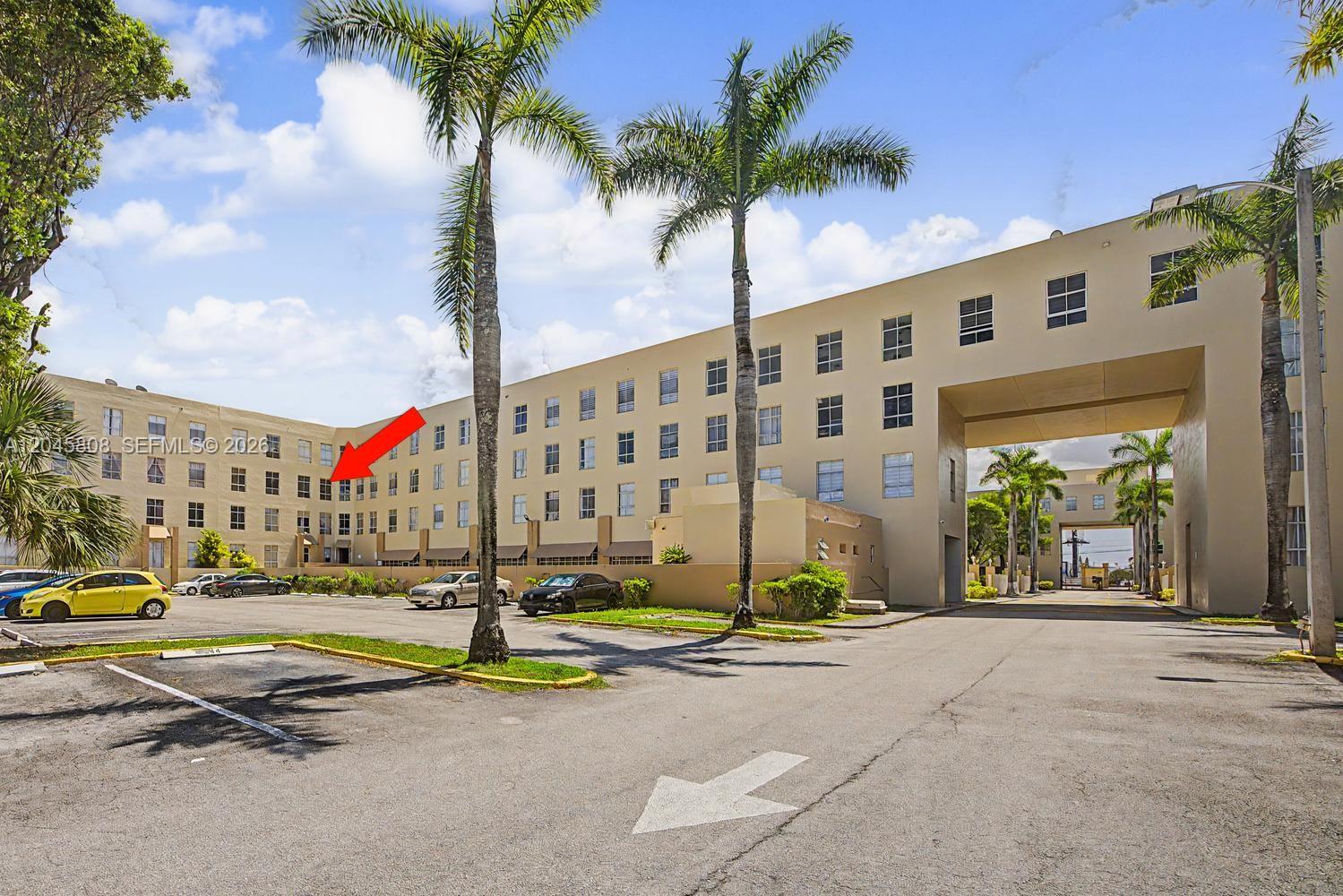 An exterior view of a multi-story apartment building with a parking lot in front — HIALEAH, FL