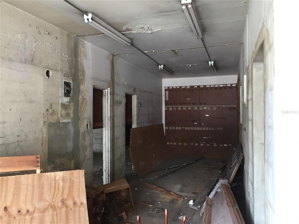 An unfinished interior space features exposed concrete walls, fluorescent lighting, and debris on the floor — 1710 Las Lomas Dev. JESUS T. PINERO AVE., SAN JUAN, PR