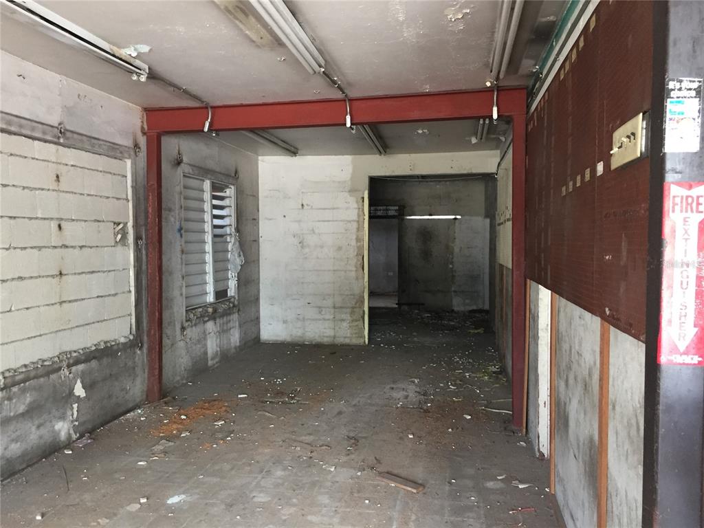 An interior view of a dilapidated commercial space with a red steel support beam — 1710 Las Lomas Dev. JESUS T. PINERO AVE., SAN JUAN, PR