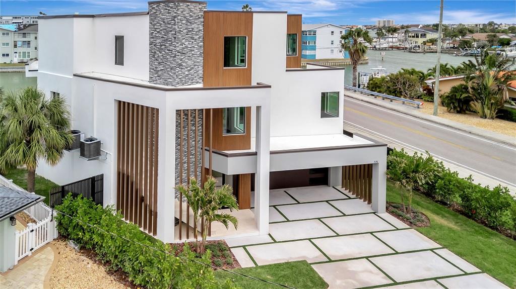 A bright living room features a white sectional sofa, round coffee table, and sliding glass doors — 7176 S SHORE DRIVE S, ST PETERSBURG, FL