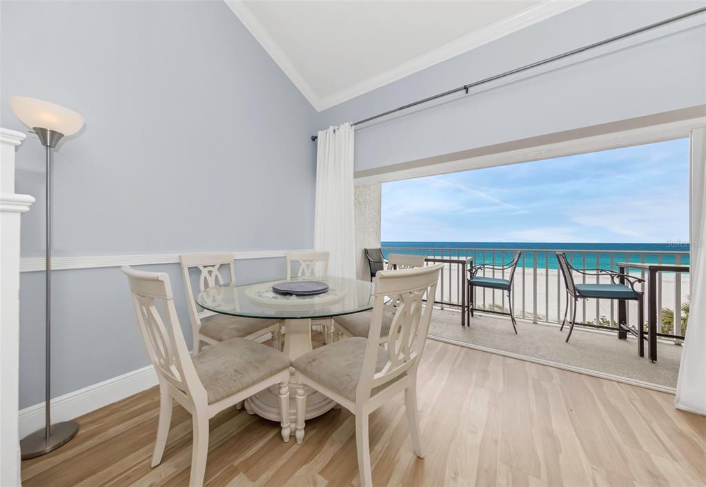 A dining area with a glass table and chairs opens onto a balcony overlooking the ocean — 20204 GULF BOULEVARD UNIT 9, INDIAN SHORES, FL