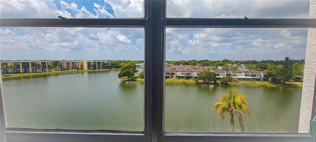 A view of a lake and residential buildings seen through a window — 3301 Spanish Moss Terrace # 219, Lauderhill FL 33319, LAUDERHILL, FL