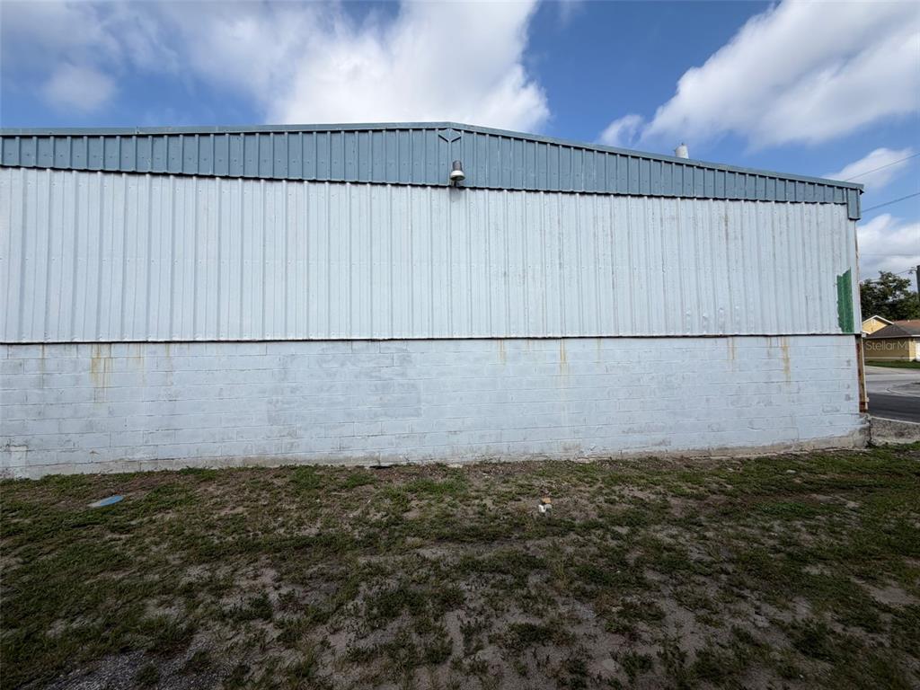 A side view of a commercial building with a metal roof and concrete block walls — 111 W PARKER STREET, LAKELAND, FL