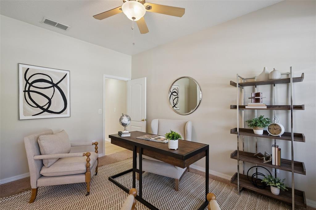 A home office features a wooden desk, two armchairs, a bookshelf, and a ceiling fan — 240 MAGNOLIA PARK TRAIL, SANFORD, FL
