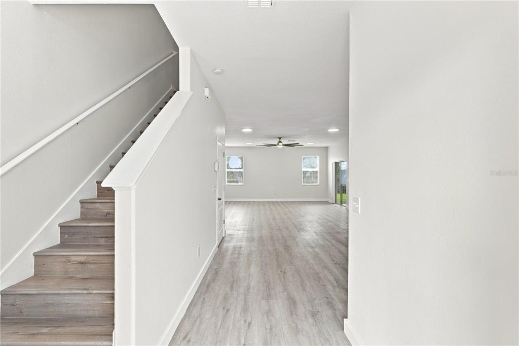 A view from an entryway looking toward a living area with stairs and wood flooring — 3538 RODRICK CIRCLE, ORLANDO, FL