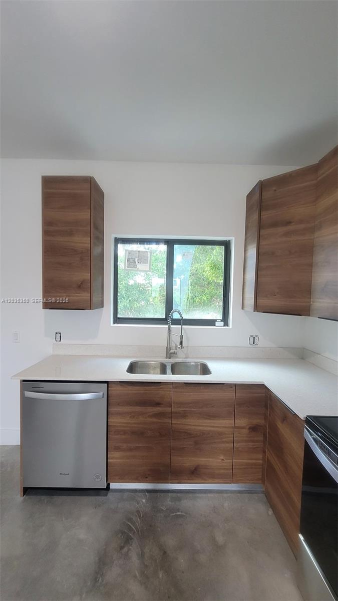 A kitchen features wood-grain cabinets, a stainless steel dishwasher, a double sink, and white countertops — 2146 NW 69th Ter # B, Miami FL 33147, MIAMI, FL