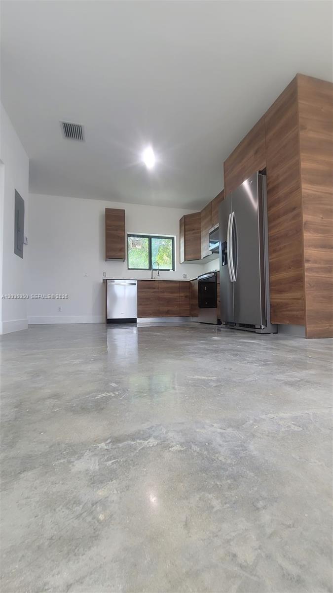 A modern kitchen features wood-grain cabinets, stainless steel appliances, and polished concrete flooring — 2146 NW 69th Ter # B, Miami FL 33147, MIAMI, FL
