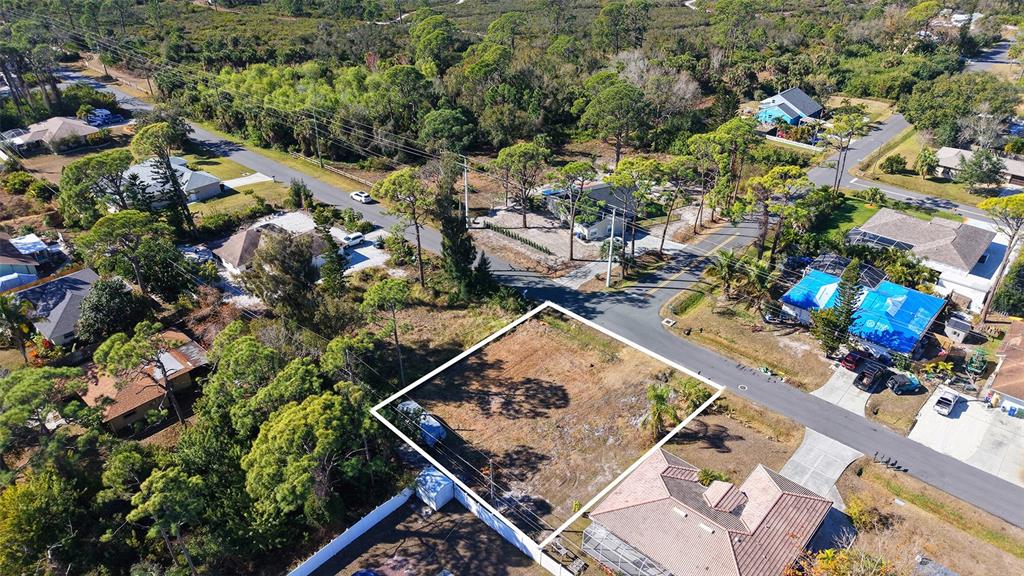 An aerial view shows a vacant, rectangular residential lot outlined in white near a street — 5993 OSPREY ROAD, VENICE, FL