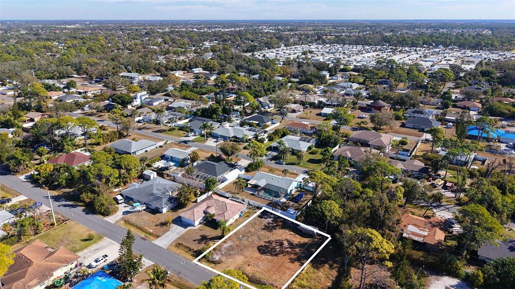 An aerial view shows a vacant, rectangular residential lot outlined in white within a suburban neighborhood — 5993 OSPREY ROAD, VENICE, FL