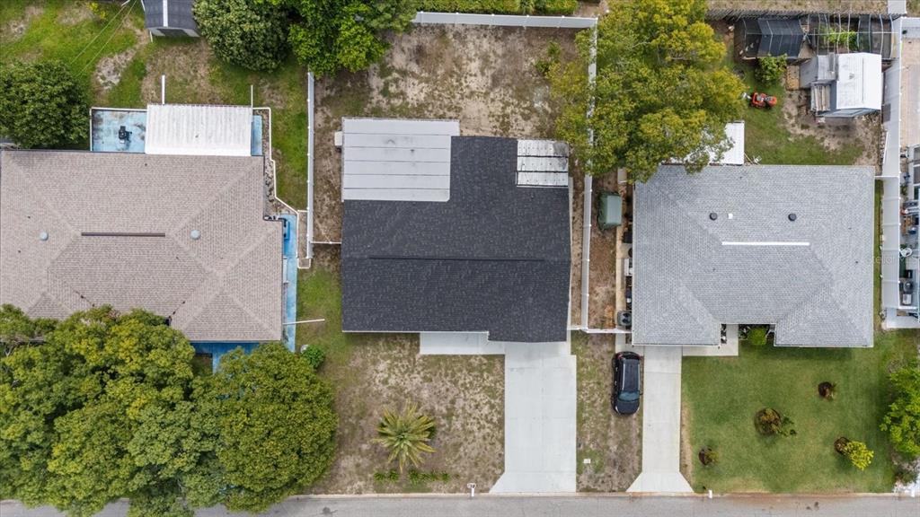 An aerial view shows three residential houses with driveways and yards from directly above — 10220 OAK HILL DRIVE, PORT RICHEY, FL