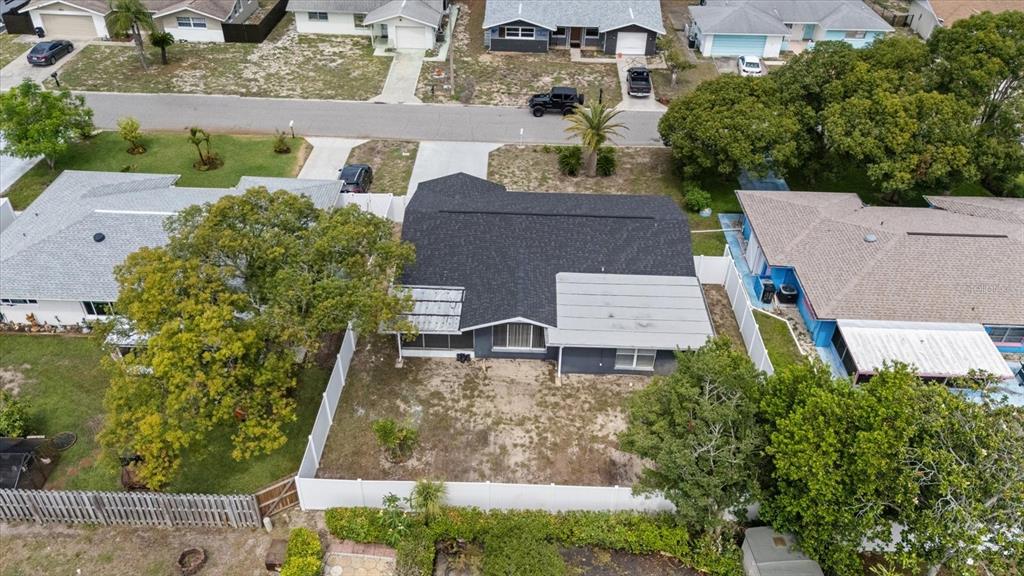 An aerial view shows a single-story house with a dark roof and a fenced backyard — 10220 OAK HILL DRIVE, PORT RICHEY, FL