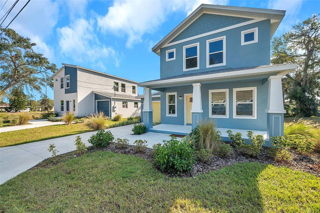 A blue two-story house with a front porch stands next to a white house — 5742 MEADOWLANE STREET, NEW PORT RICHEY, FL