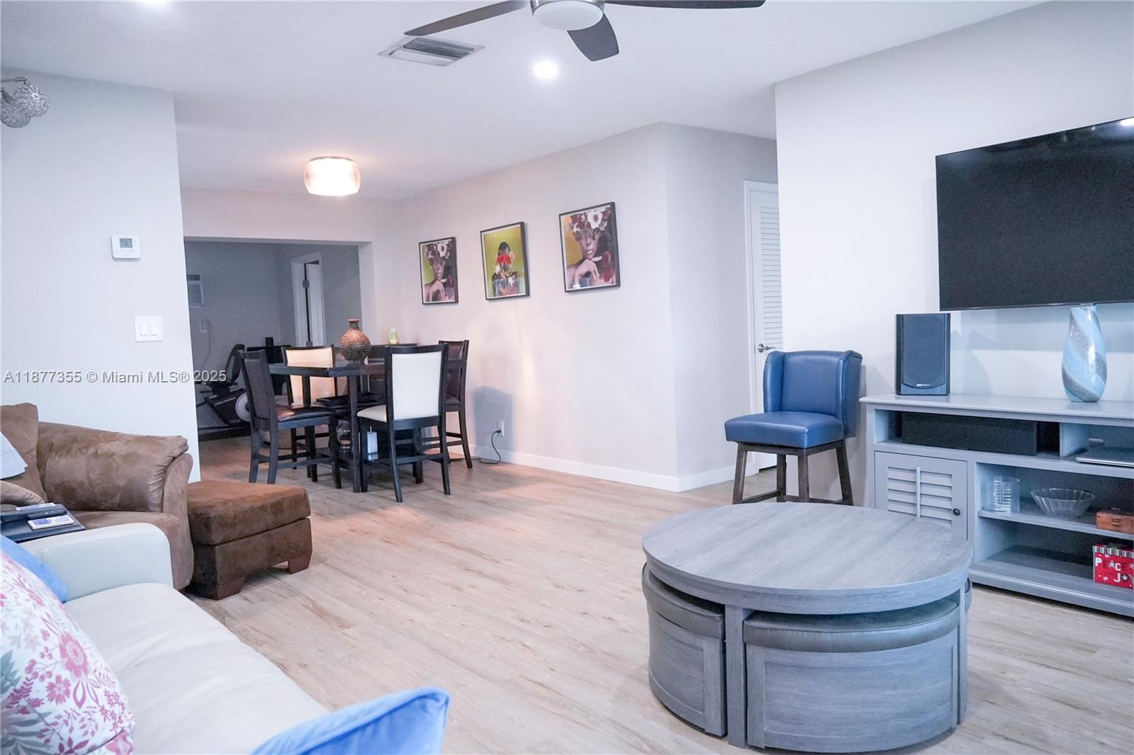 A living room features light wood flooring, a circular coffee table, and a dining area — 4401 NW 45th St, Tamarac FL 33319, TAMARAC, FL