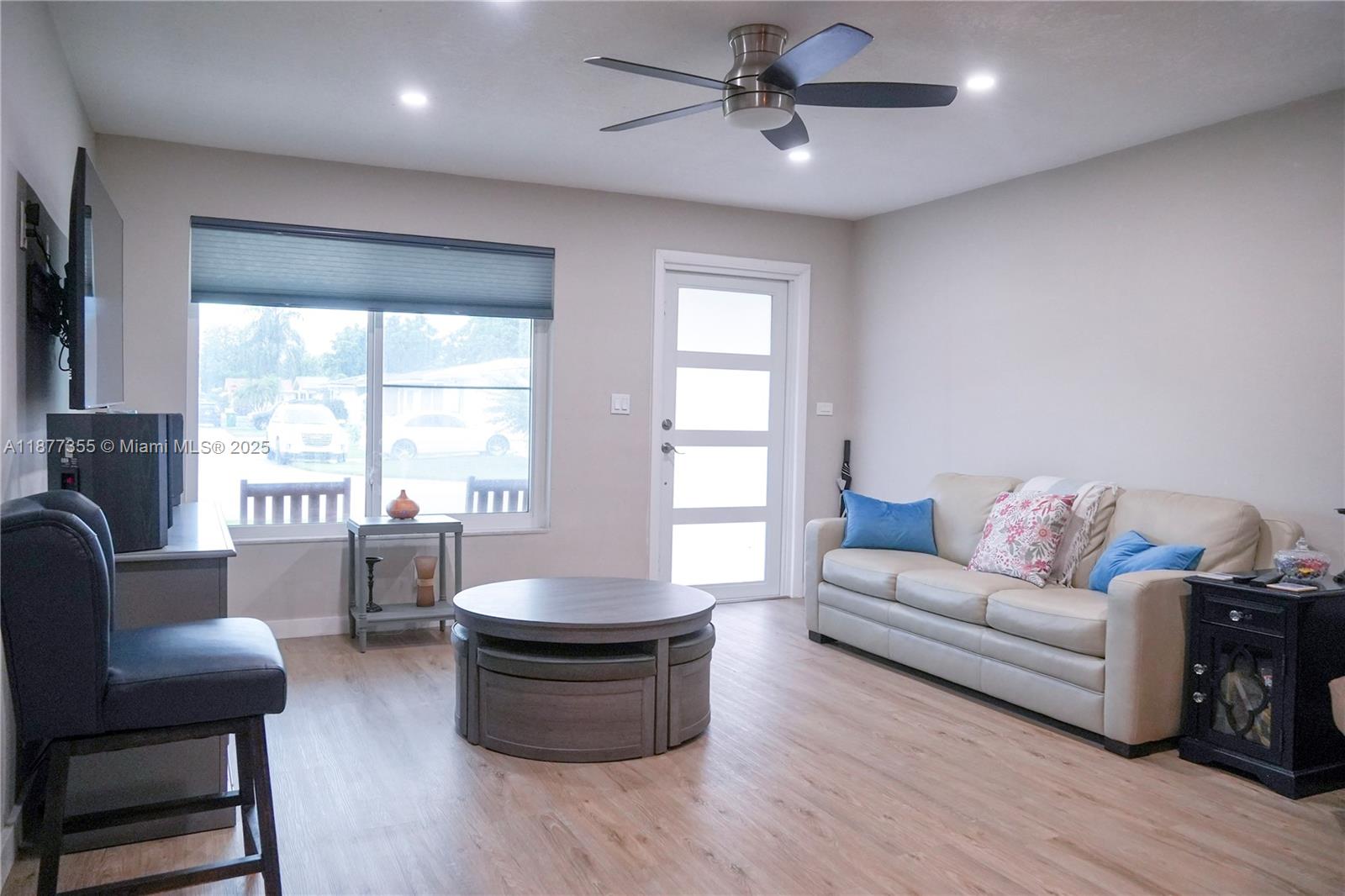 A living room features light wood-look flooring, a beige sofa, and a round coffee table — 4401 NW 45th St, Tamarac FL 33319, TAMARAC, FL
