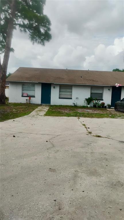 A living room features a grey sofa, a patterned rug, a wall clock, and tile flooring — 1011 57TH AVENUE TERRACE E, BRADENTON, FL