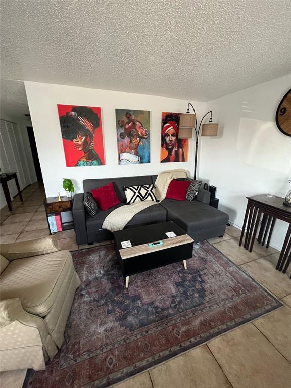 A living room features a gray sectional sofa, a coffee table, and three portraits on the wall — 1011 57TH AVENUE TERRACE E, BRADENTON, FL