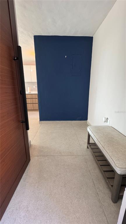 An entryway features a wooden door, a beige bench, and a blue accent wall — VILLA CAPARRA TOWER 44 A UNIT 6-A, GUAYNABO, PR
