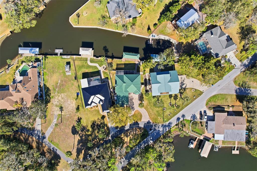 An aerial view shows several waterfront houses with pools and private docks along a canal — 300 NW 12TH AVENUE, CRYSTAL RIVER, FL