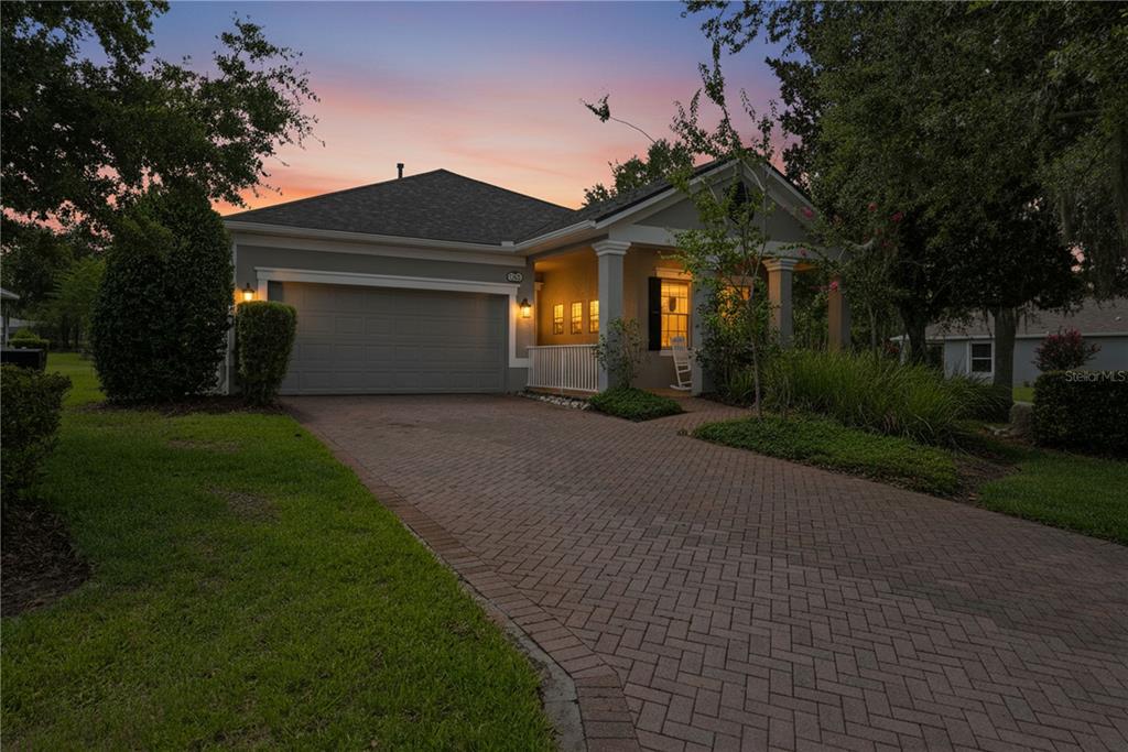 A single-story house with a brick driveway, two-car garage, and a covered front porch — 5421 CAPPLEMAN LOOP, BROOKSVILLE, FL