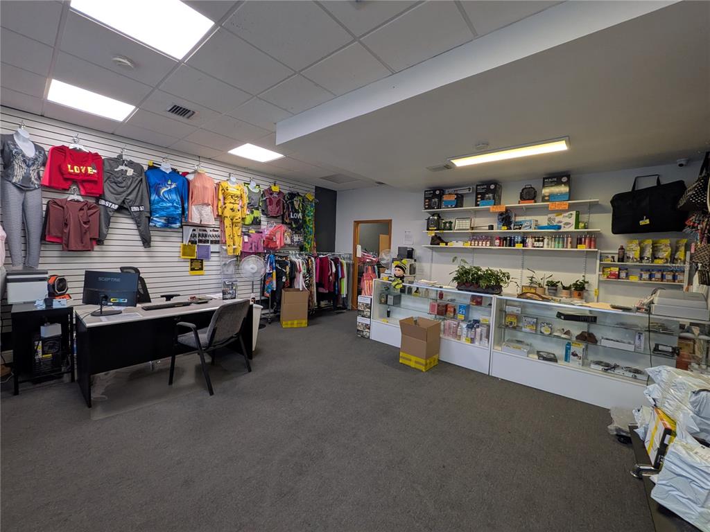 A retail store interior features clothing on wall racks, a service desk, and glass display cases — 1160 W STATE ROAD 436 UNIT 1150, ALTAMONTE SPRINGS, FL