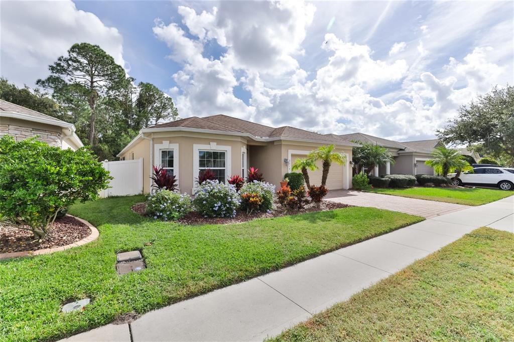 A single-story tan house with a paved driveway, a front lawn, and landscaping — 3849 BOURBON STREET, PORT ORANGE, FL