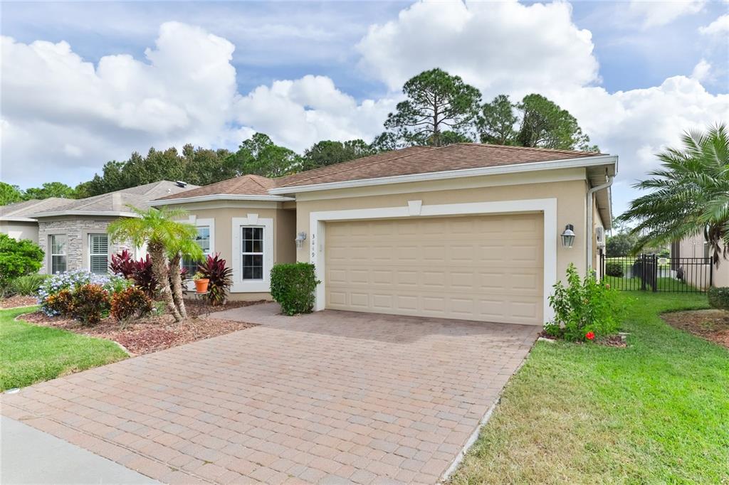 A single-story house with a beige stucco exterior, a two-car garage, and a paved driveway — 3849 BOURBON STREET, PORT ORANGE, FL