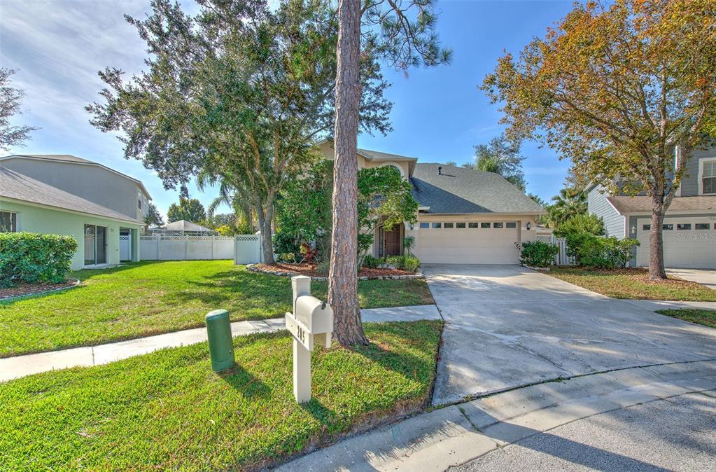 A two-story suburban house with a beige exterior, a two-car garage, and a front lawn — 9205 CELEBRATION COURT, TAMPA, FL