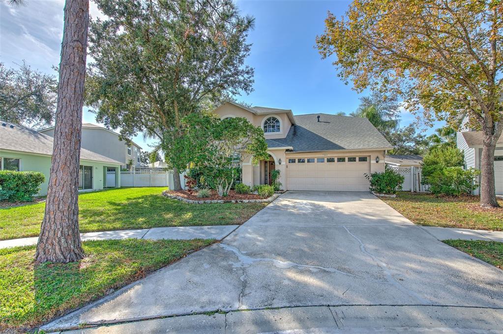 A two-story house with a beige exterior, a two-car garage, and a concrete driveway — 9205 CELEBRATION COURT, TAMPA, FL