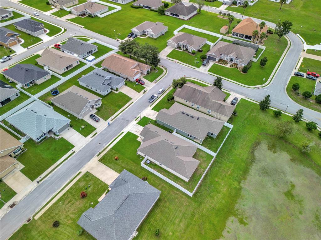 An aerial view shows a suburban neighborhood with single-family homes, paved streets, and green lawns — 4448 NW 2ND COURT, OCALA, FL