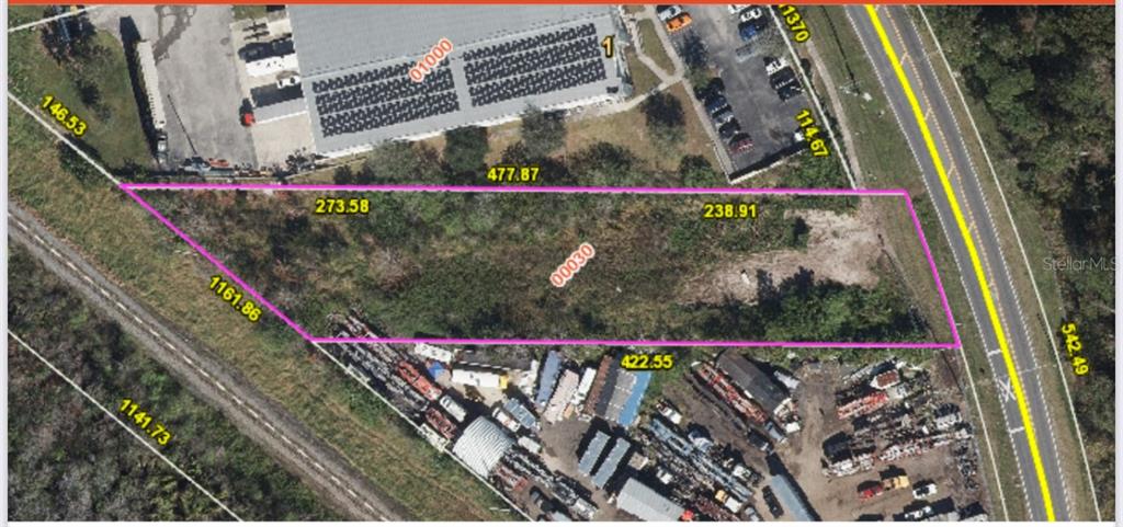 An aerial view shows a vacant, irregularly shaped plot of land outlined in pink — BOGGY CREEK ROAD, ORLANDO, FL