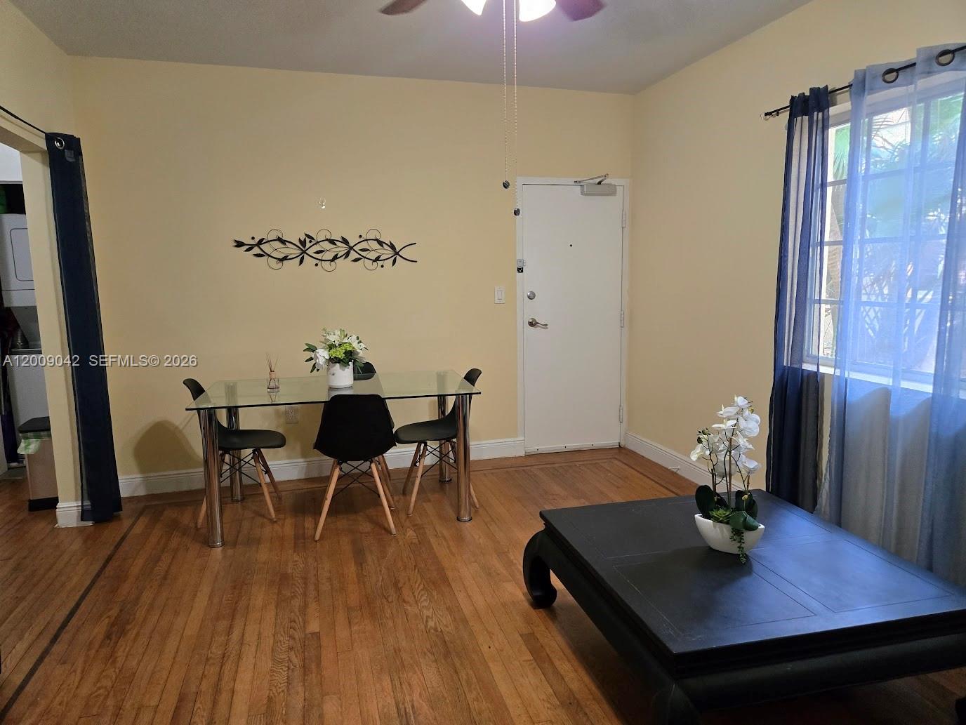 A dining area with a glass table and a living area with a coffee table — 1219 Meridian Ave # 2, Miami Beach FL 33139, MIAMI BEACH, FL