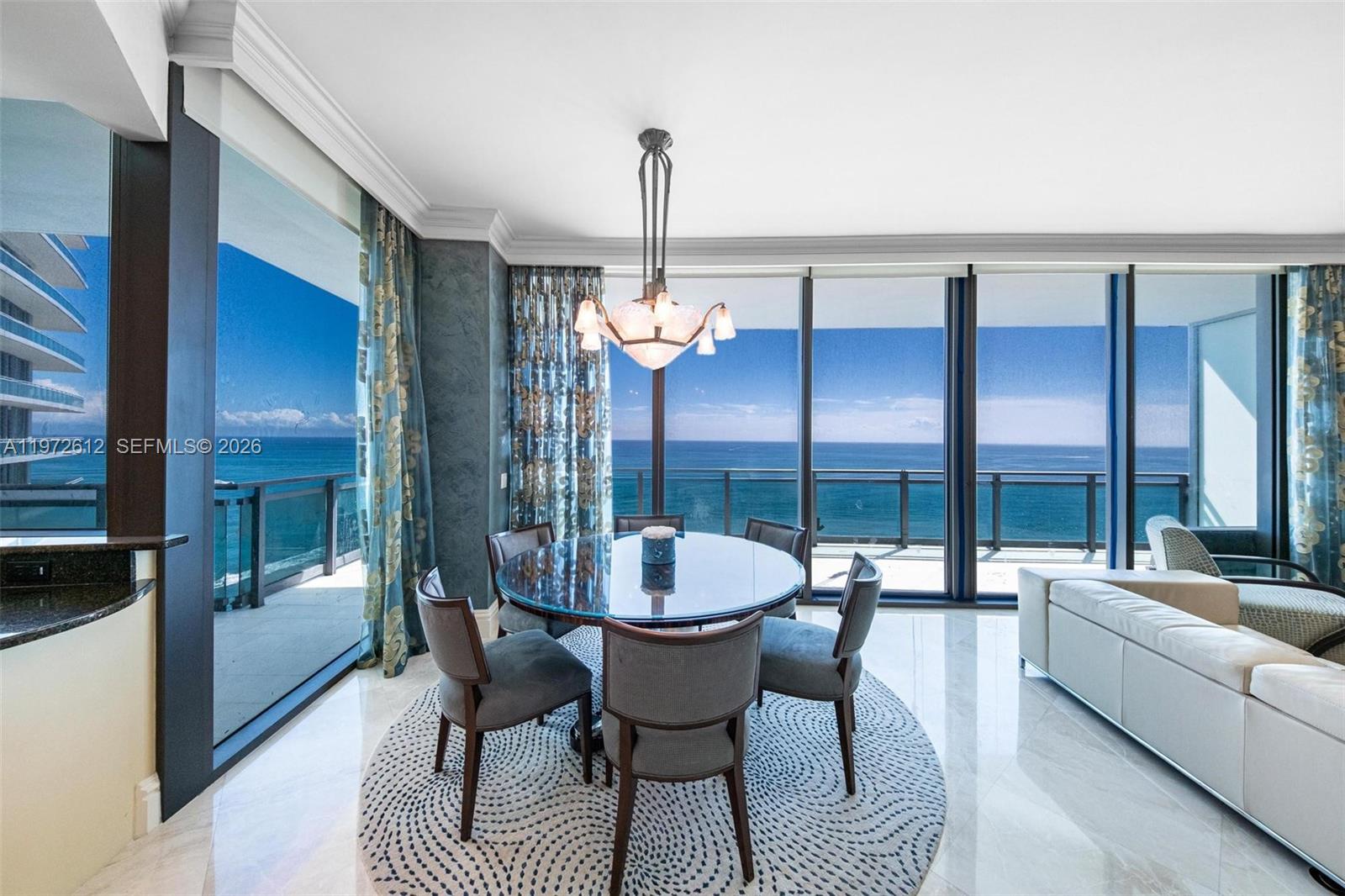 A kitchen with granite countertops and a wine cooler overlooks a dining area and ocean — 10295 Collins Ave # 1502, Bal Harbour FL 33154, BAL HARBOUR, FL