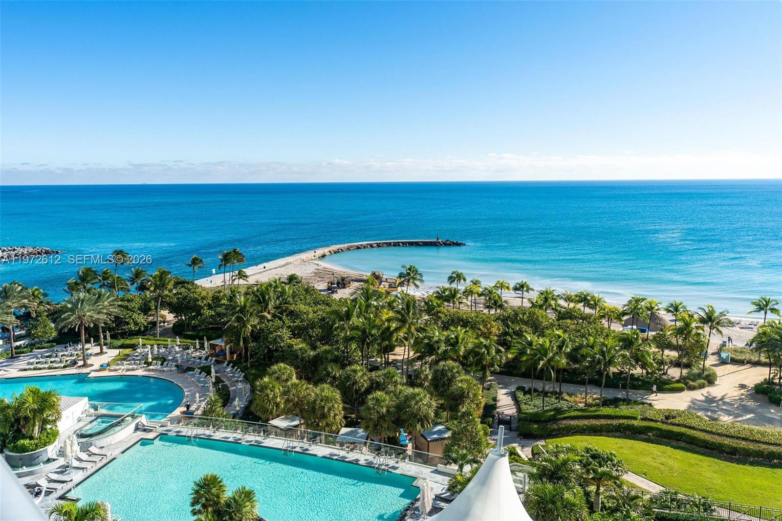A dining area features a glass-topped table, upholstered chairs, and floor-to-ceiling windows overlooking the ocean — 10295 Collins Ave # 1502, Bal Harbour FL 33154, BAL HARBOUR, FL