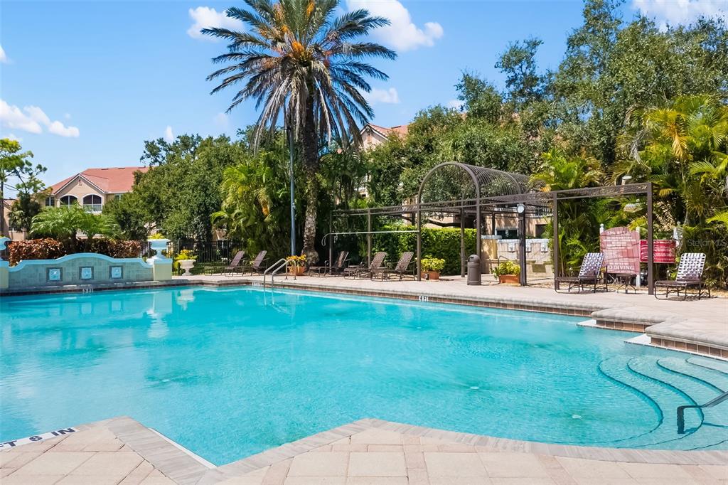A sign for Bella Villino Condominiums on Palmer Ranch sits amidst landscaping and mature trees — 4142 CENTRAL SARASOTA PARKWAY UNIT 1415, SARASOTA, FL