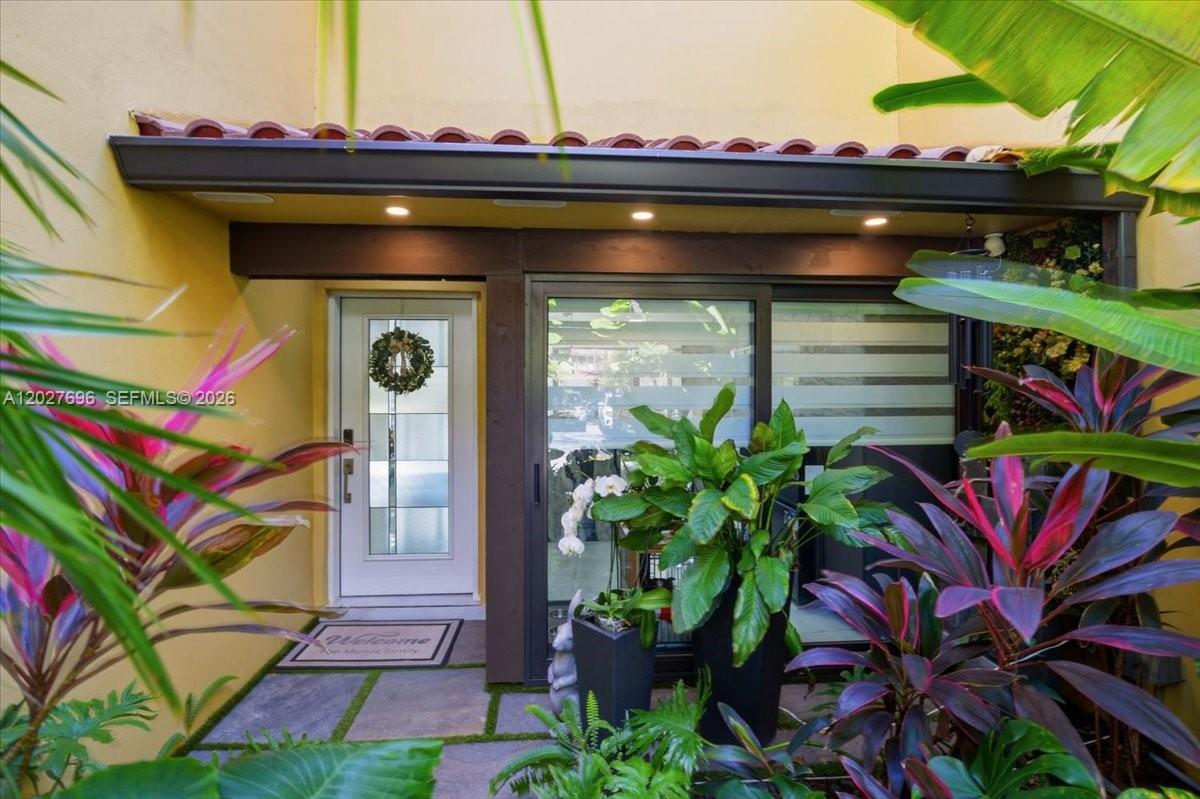 The exterior entrance features a white door, sliding glass doors, and lush tropical landscaping — 3629 Estepona Ave # 27, Doral FL 33178, DORAL, FL