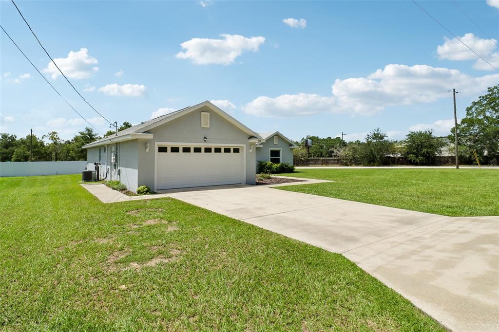 A light gray single-story house with a two-car garage and a concrete driveway — 9170 SE 150TH STREET, SUMMERFIELD, FL