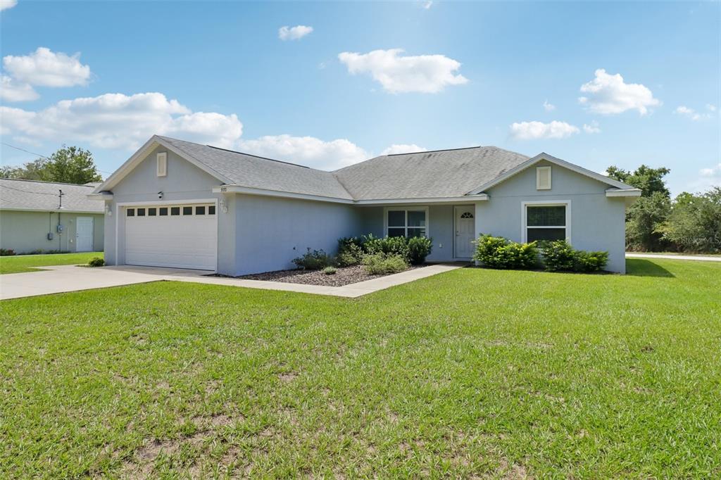A single-story house with a light gray exterior, a two-car garage, and a front lawn — 9170 SE 150TH STREET, SUMMERFIELD, FL