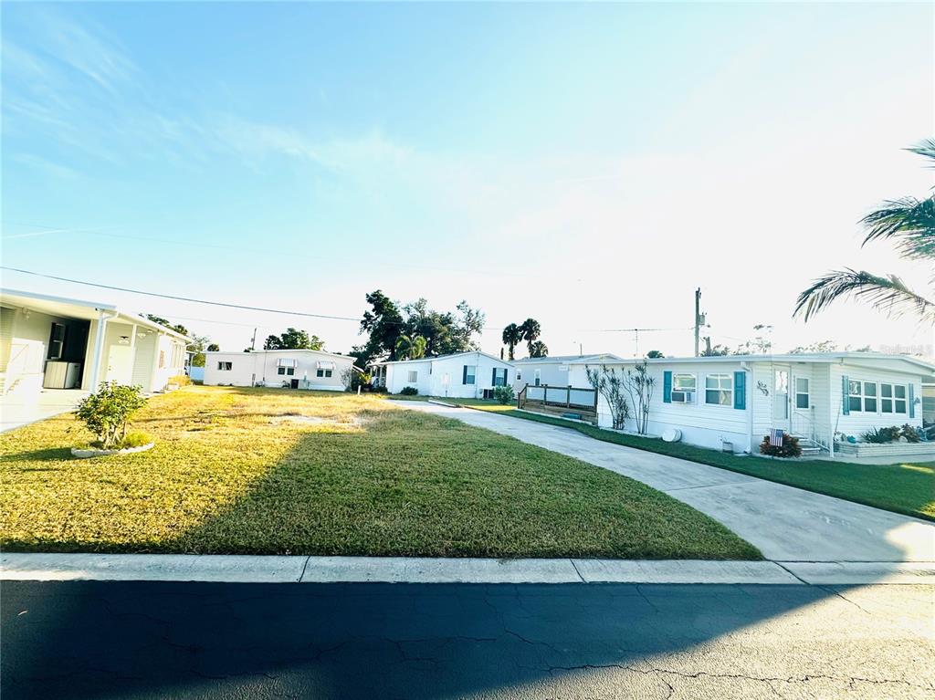 A grassy lot sits between two manufactured homes under a clear blue sky — 522 CENTRE STREET, PALMETTO, FL