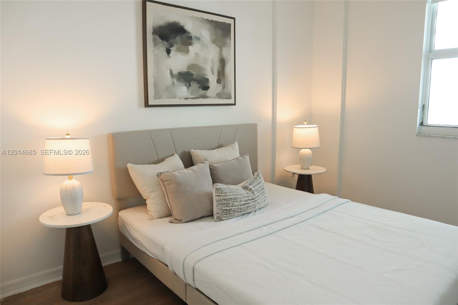 A bedroom features a bed with a neutral headboard, two side tables, and wall art — 9172 Collins Ave # 212, Surfside FL 33154, SURFSIDE, FL
