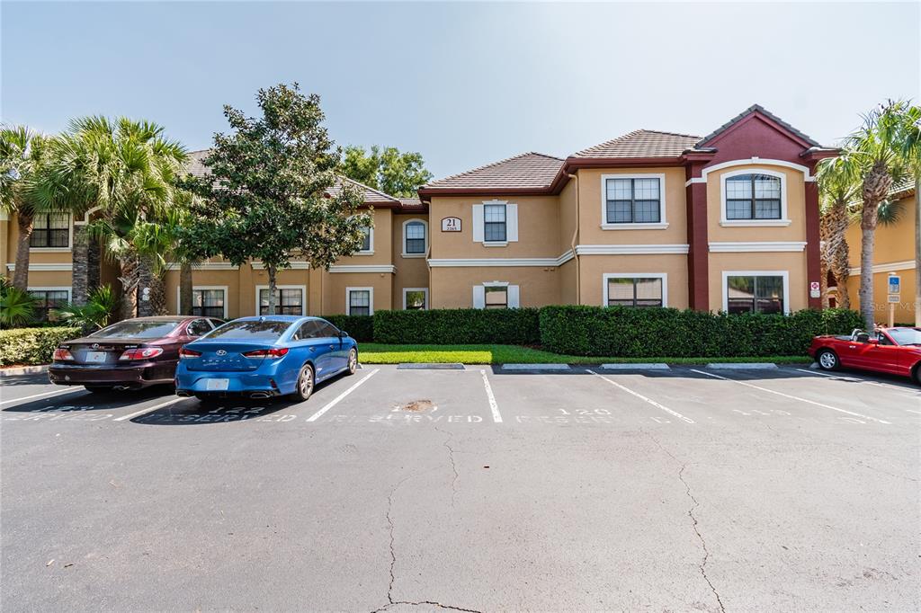 A two-story apartment building with a parking lot in the foreground — 2265 PORTOFINO PLACE UNIT 21-212, PALM HARBOR, FL