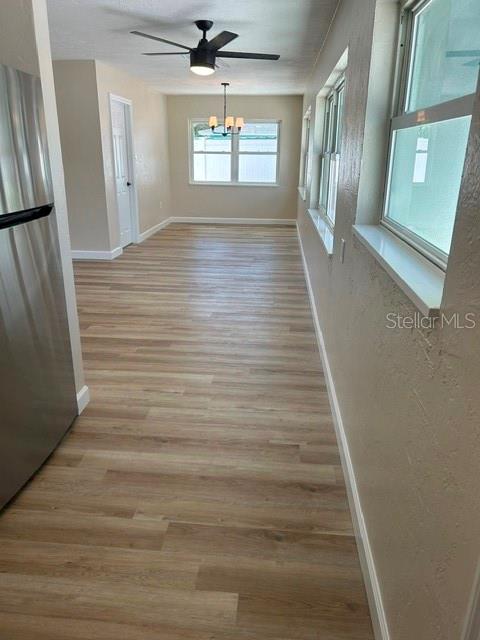 A room with light wood-look flooring, a ceiling fan, and a window overlooking the exterior — 3066 66TH WAY N, ST PETERSBURG, FL